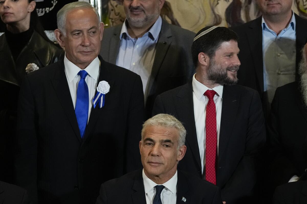 Israeli Prime Minister Yair Lapid, center, Likud Party leader Benjamin Netanyahu, left, and others
