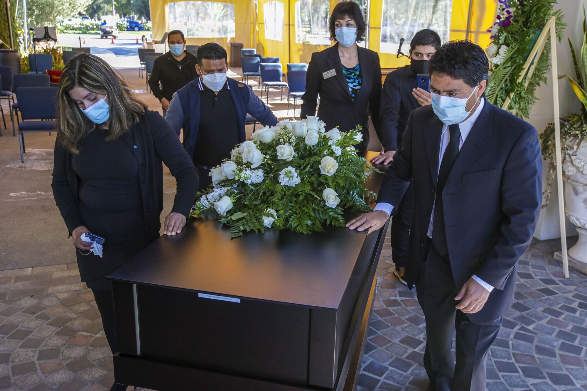 Family members escort a coffin.