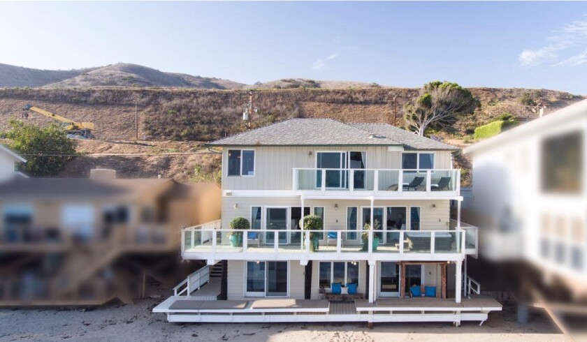 The three-story house sits on the beach in Malibu.