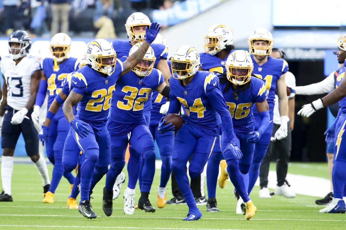 Nasir Adderley (24) celebrates his interception against the Titans with Chargers teammates.