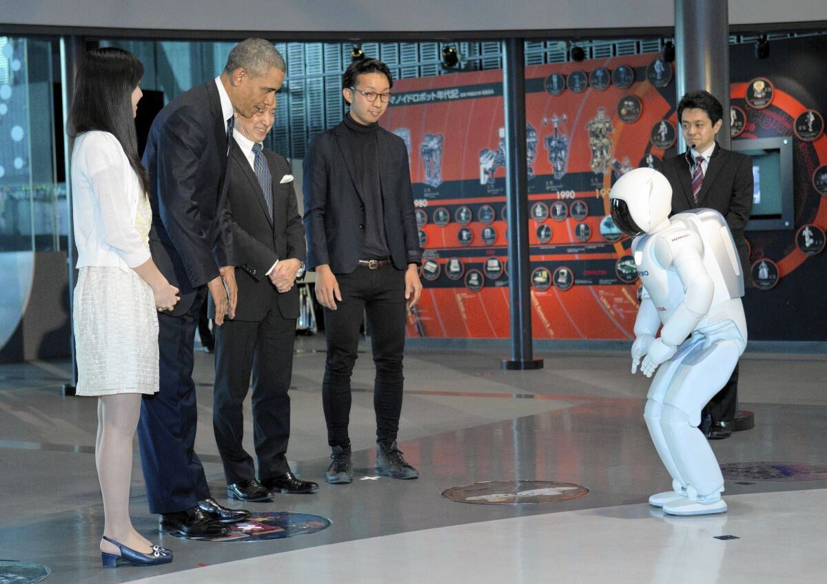 President Obama interacts with a robot known as ASIMO during a youth science event at the National Museum of Emerging Science and Innovation in Tokyo.