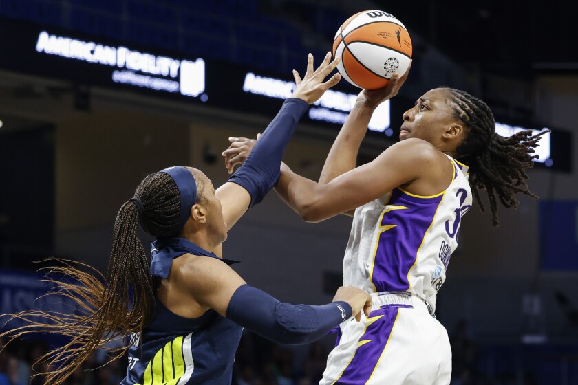 Los Angeles Sparks forward Nneka Ogwumike, right, drives to the basket past Dallas Wings forward Kayla Thornton during the second half of a WNBA basketball game Friday, July 1, 2022 in Arlington, Texas. (Shafkat Anowar/The Dallas Morning News via AP)