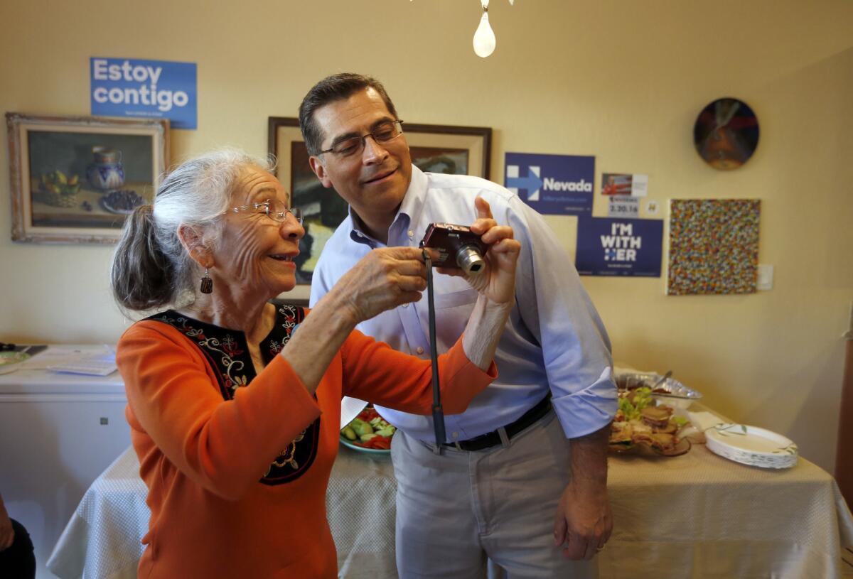 LAS VEGAS - Maria Gray, shows Xavier Becerra (CA-34), right, a U.S. Representative of Los Angeles and Chairman of the House Democratic Caucus, a photo in her home in Las Vegas. (Francine Orr/ Los Angeles Times)