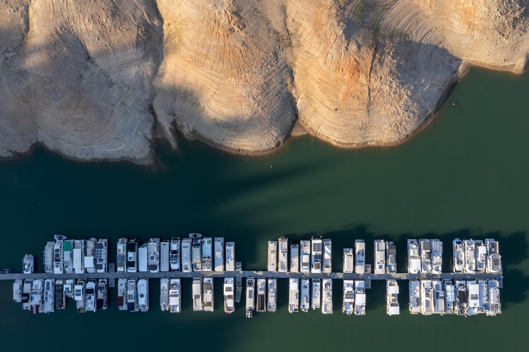 Boats are tied up at a Lake Shasta marina, hundreds of feet below where they are usually moored.