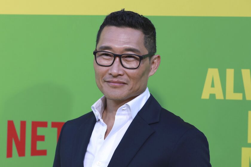 Daniel Dae Kim posing in glasses and a navy suit