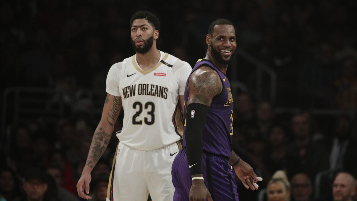Lakers' LeBron James, right, smiles as he walks past New Orleans Pelicans' Anthony Davis during the first half.