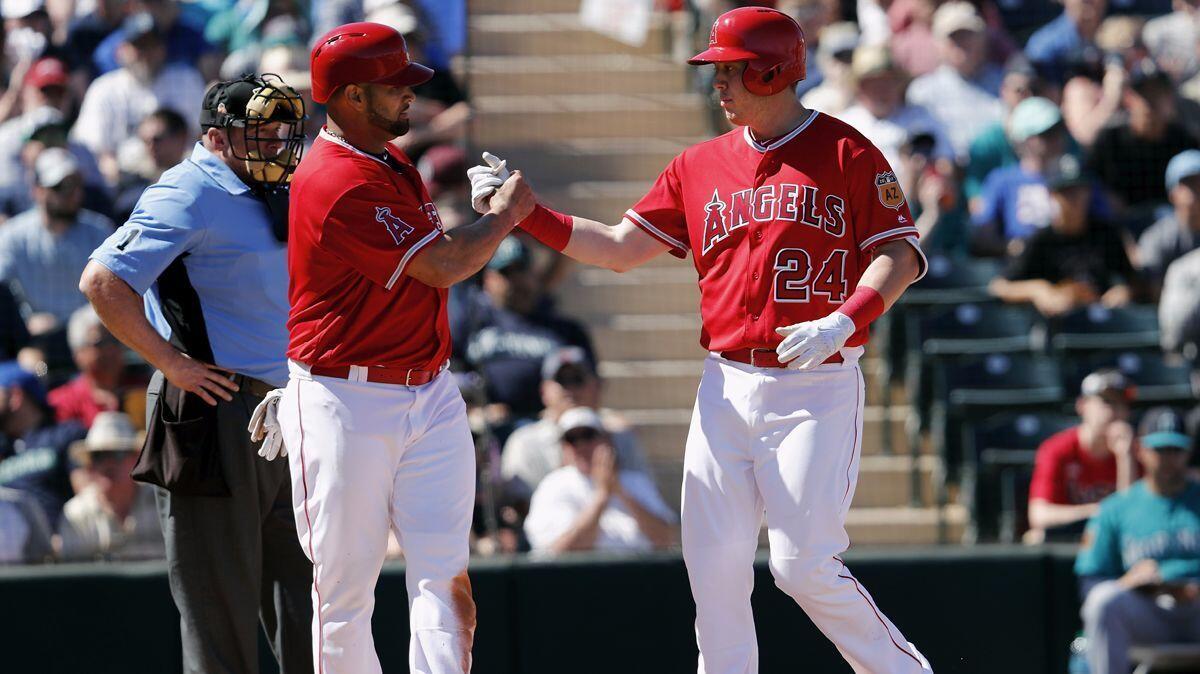 Albert Pujols, left, salutes Angels teammate C.J. Cron, who hit a two-run homer in the third inning at Tempe (Ariz.) Diablo Stadium.
