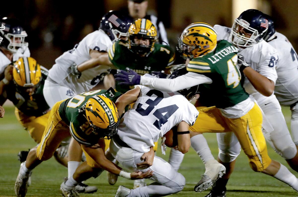 Edison's Peyton Gregory (20) and Hudson Letterman (47) close in on Newport Harbor's Payton Irving (34) for a loss of yards.