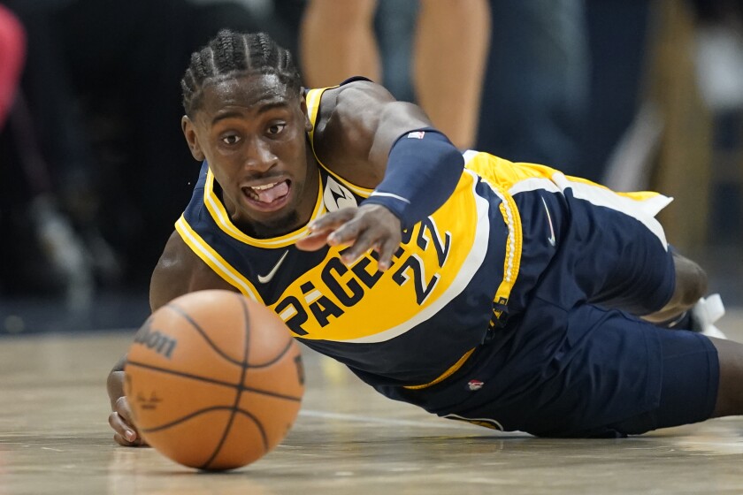 Indiana Pacers' Caris LeVert dives for a looser ball during the first half of an NBA basketball game against the Detroit Pistons, Thursday, Dec. 16, 2021, in Indianapolis. (AP Photo/Darron Cummings)