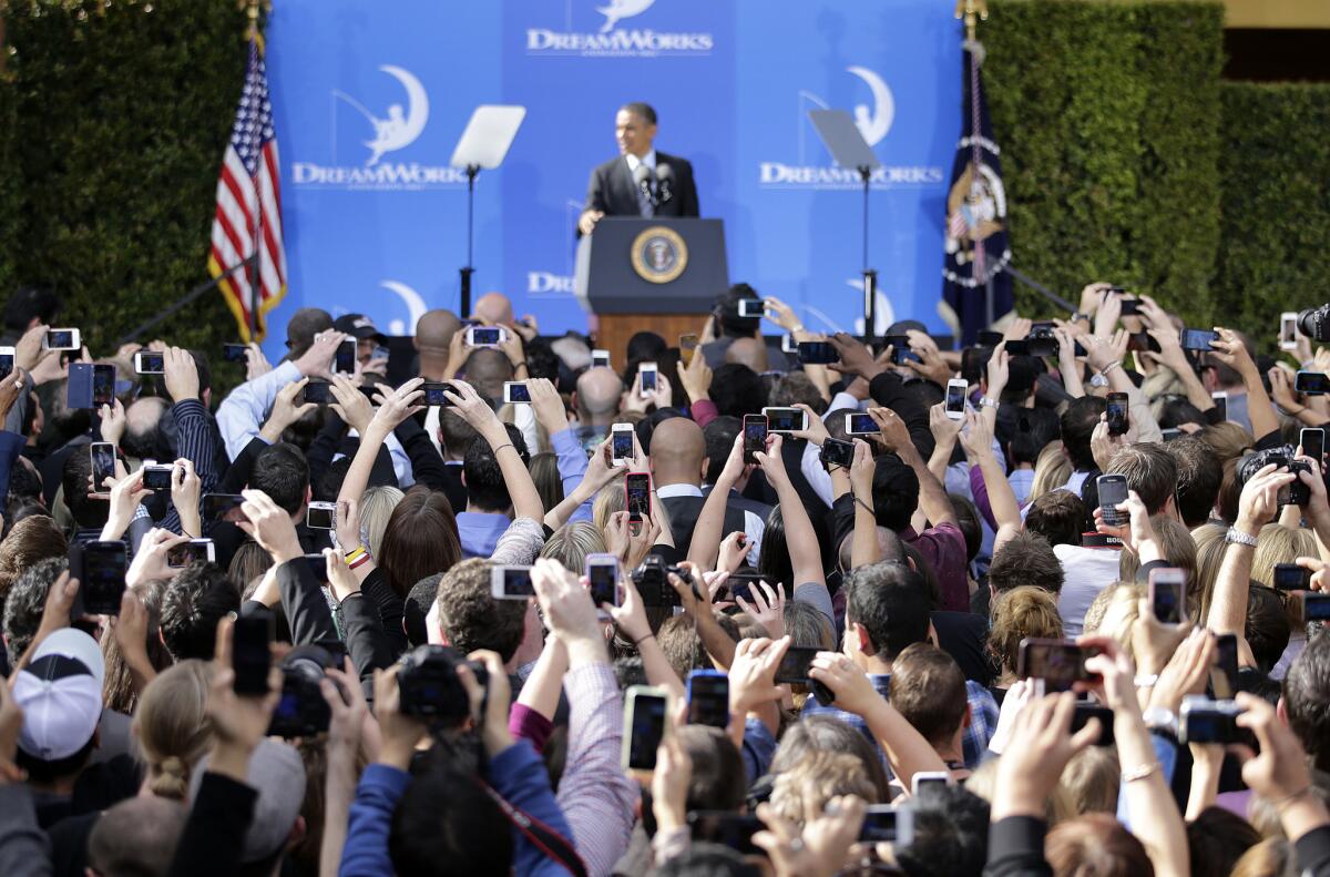 People take pictures of President Obama as he speaks at the DreamWorks Animation studio Tuesday in Glendale.