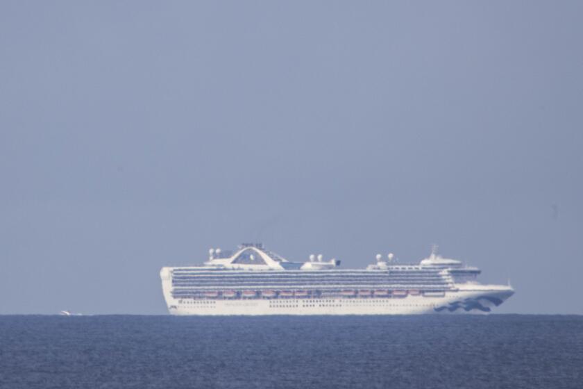 A small vessel approaches the Grand Princess cruise ship as it waits offshore from San Francisco, Calif. in Pacifica, CA, USA 8 Mar 2020. (Peter DaSilva for The Los Angeles Times)