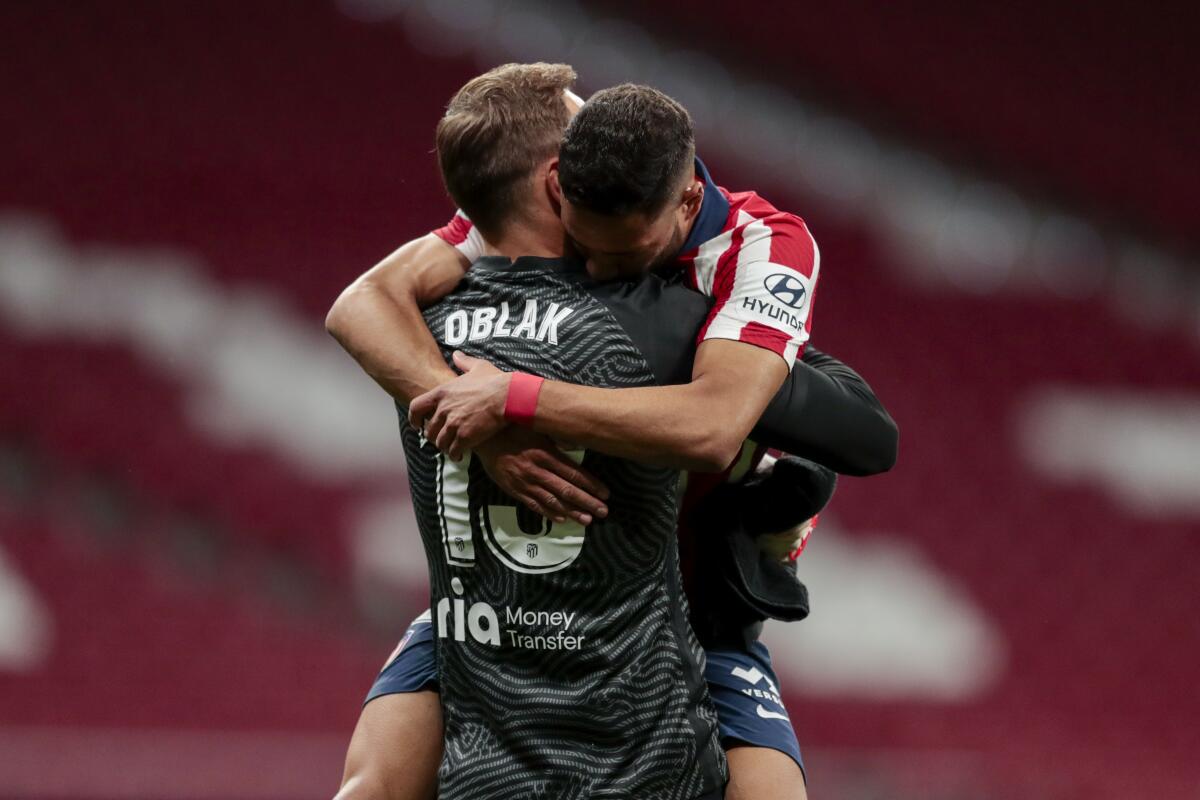 El arquero Jan Oblak abraza a Renán Lodi, su compañero del Atlético de Madrid.