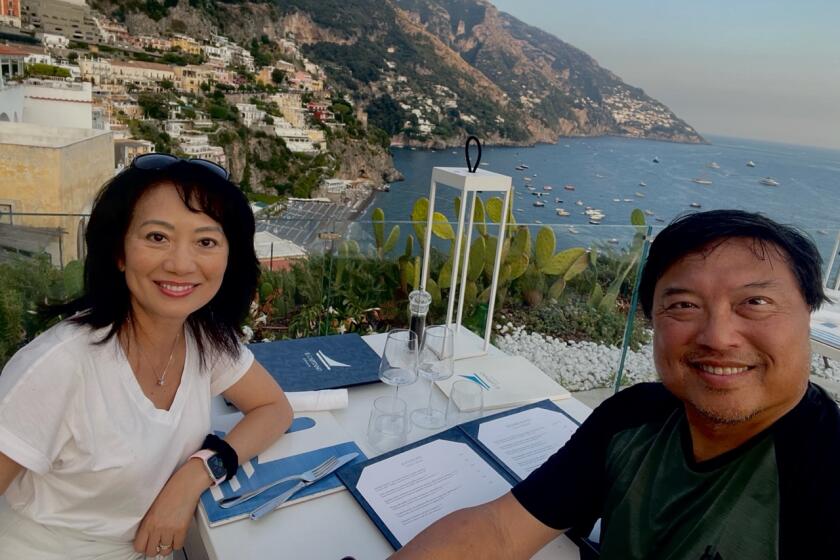 Wayne Chan and his wife, Maya, on vacation at a cliff side restaurant with a stunning view of the Amalfi coast.