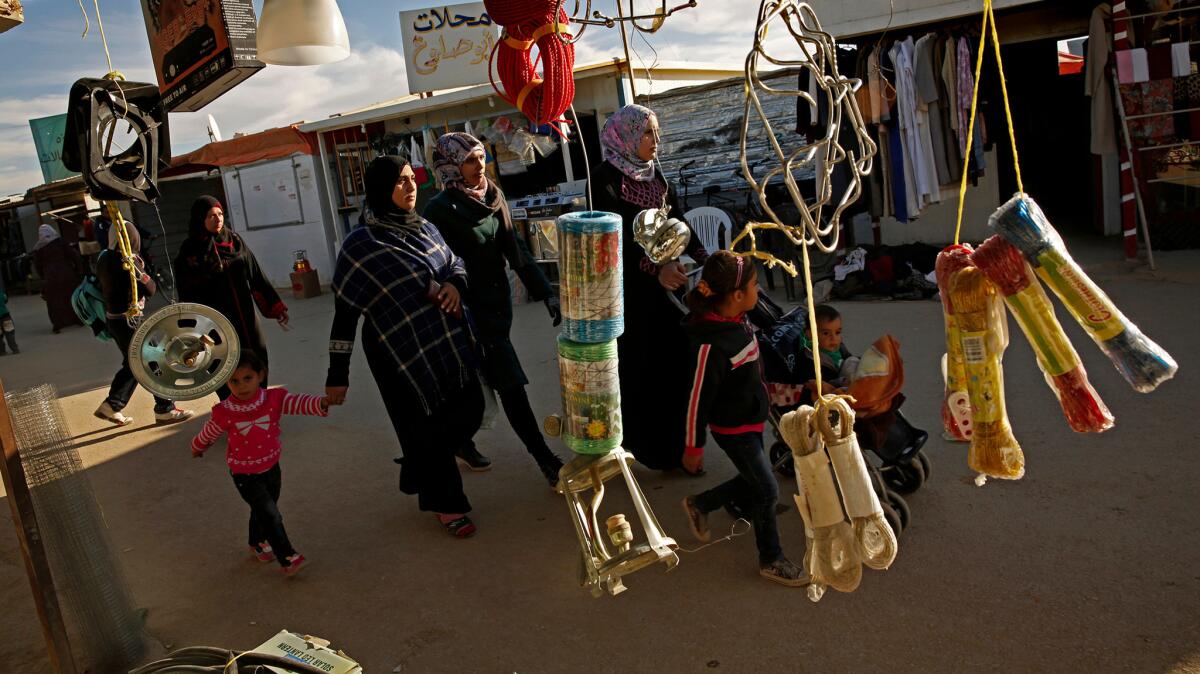 Women and children stroll through a business sector of Jordan’s Zaatari refugee camp, home to more than 85,000 Syrian refugees.