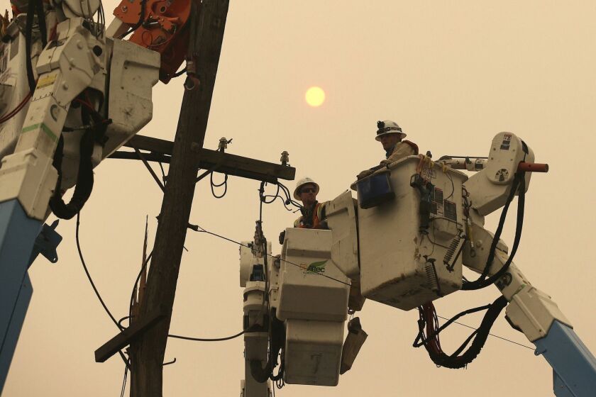FILE - In this Nov. 9, 2018 file photo, Pacific Gas & Electric crews work to restore power lines in Paradise, Calif. Californias largest utility company is getting battered in midday trading on a report that its considering bankruptcy protection in the face of potentially crippling liability damages from a spate of recent wildfires. No cause has been determined for the source of Californias Camp Fire, but PG&E reported an outage around the time and place the fire was ignited. Another transmission line also malfunctioned a short time later, possibly sparking a second fire. (AP Photo/Rich Pedroncelli, File)