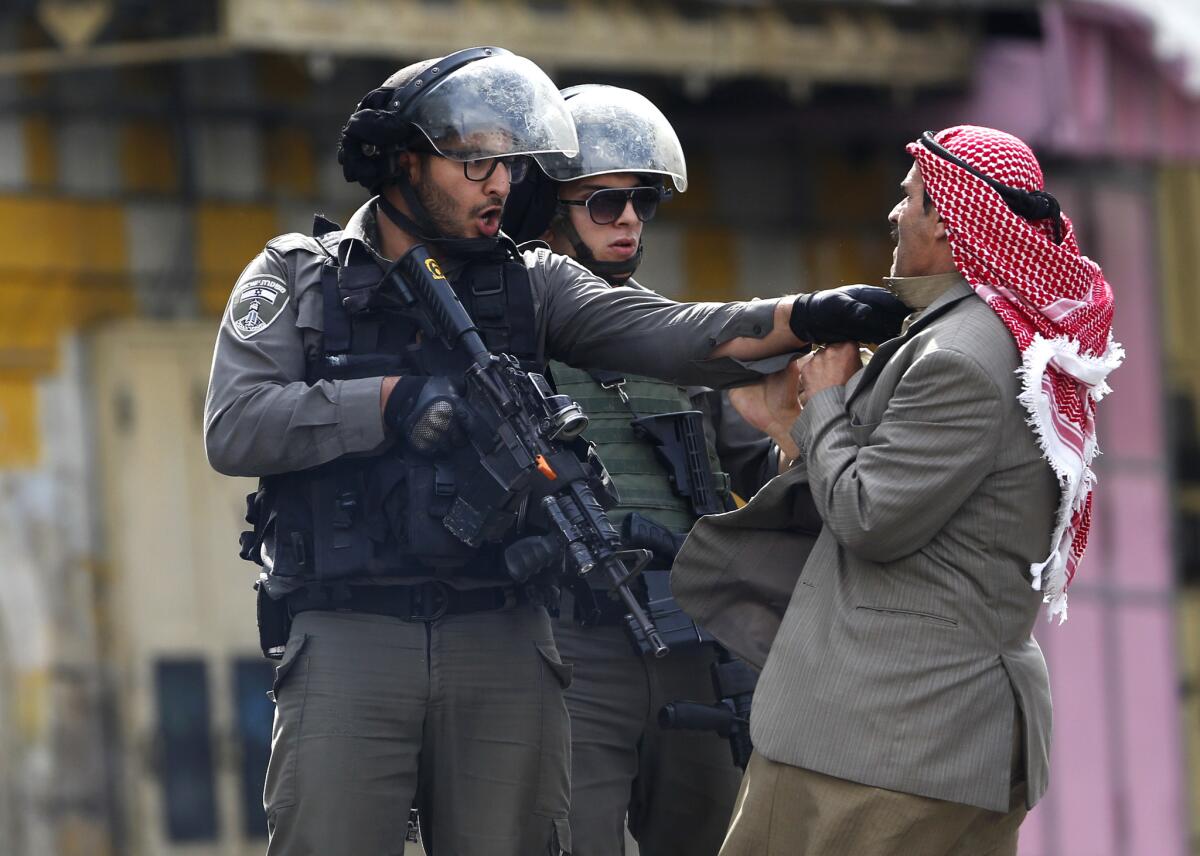 A Palestinian is pushed by an Israeli policemen amid clashes in Hebron, West Bank, on Saturday.