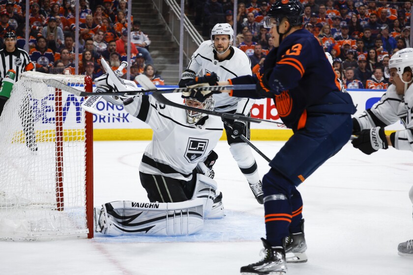Kings goalkeeper Jonathan Quick clears the puck as Edmonton Oilers right winger Jesse Puljujarvi tries to deflect it.