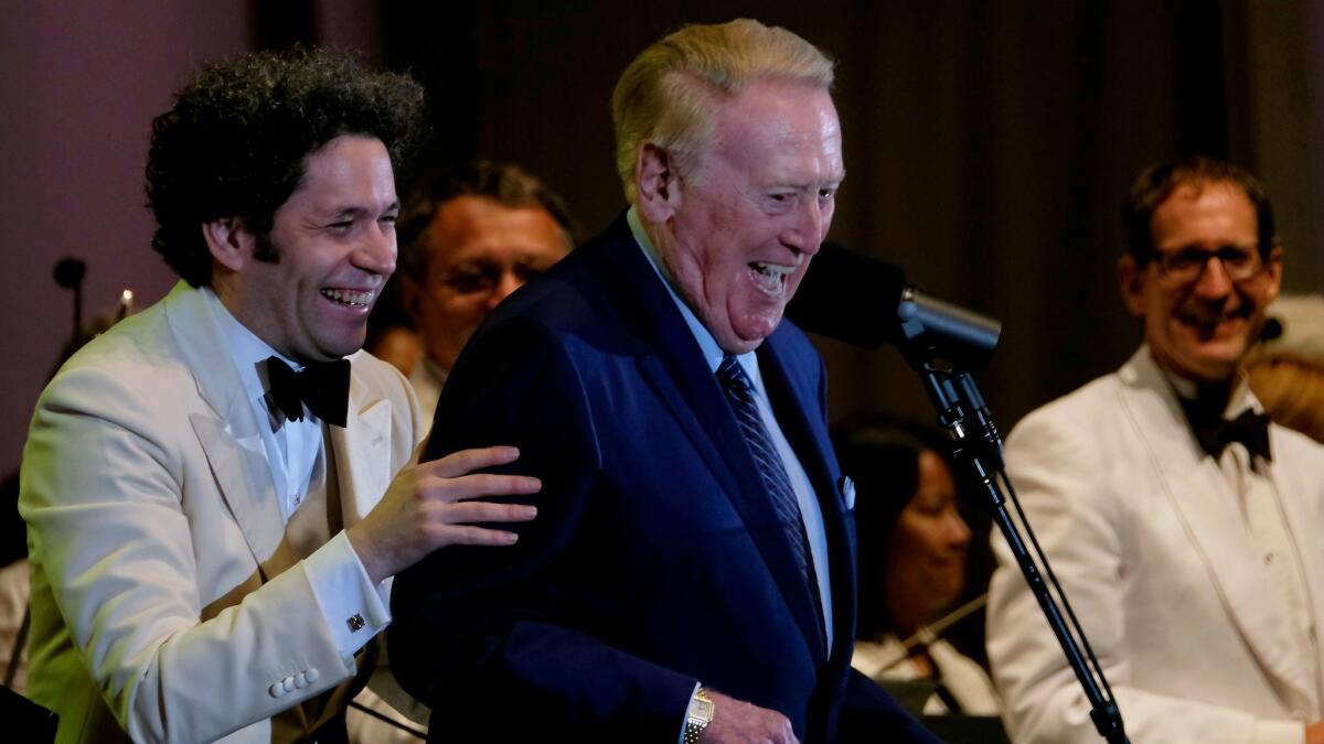 Gustavo Dudamel, left, and Vin Scully take a bow after performing Copland's "Lincoln Portrait" with the Los Angeles Philharmonic at the Hollywood Bowl on Thursday night.