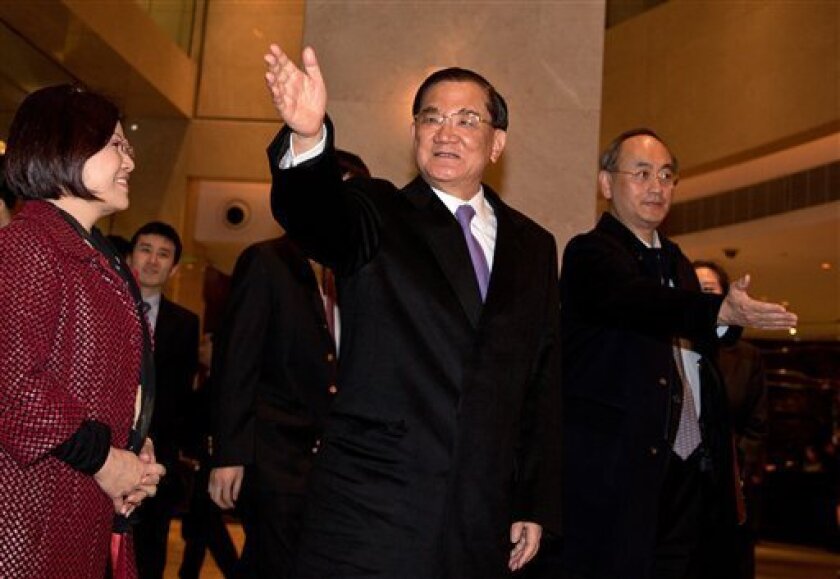 Taiwan's former vice president Lien Chan, center, waves to journalists upon arrival at a hotel in Beijing Sunday, Feb. 24, 2013. Lien Chan leads a business and politician delegation to Beijing for a three day visit and will meet with Chinese President Hu Jintao and Communist Party Secretary General and the country's new leader Xi Jinping. (AP Photo/Andy Wong)