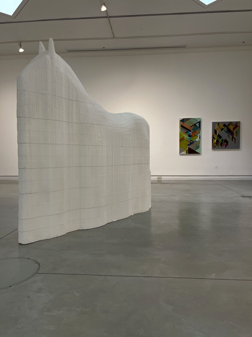 An installation view of Ed Gomez's "Pale Rider," left, and paintings by Kevin Scianni.
