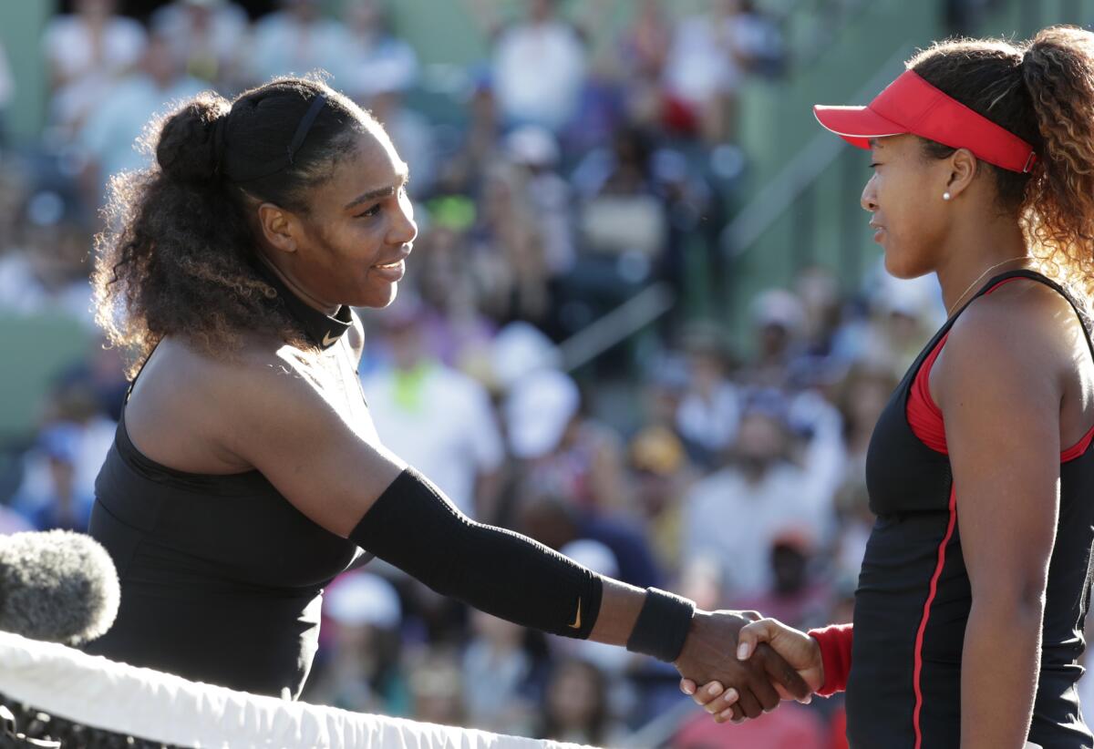 Naomi Osaka shakes hands with Serena Williams.