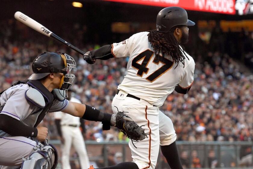 Johnny Cueto gets a base-hit during the bottom of the second inning of a game against the Rockies on July 6.