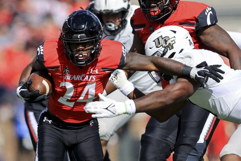 Cincinnati running back Jerome Ford (24) carries the ball as he breaks a tackle.