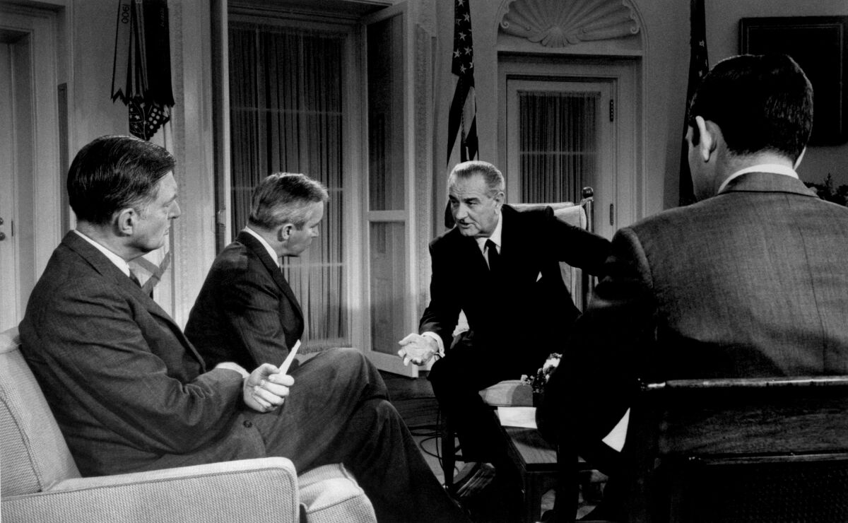 From left, NBC News' Ray Scherer, ABC News' Frank Reynolds and President Lyndon B. Johnson.
