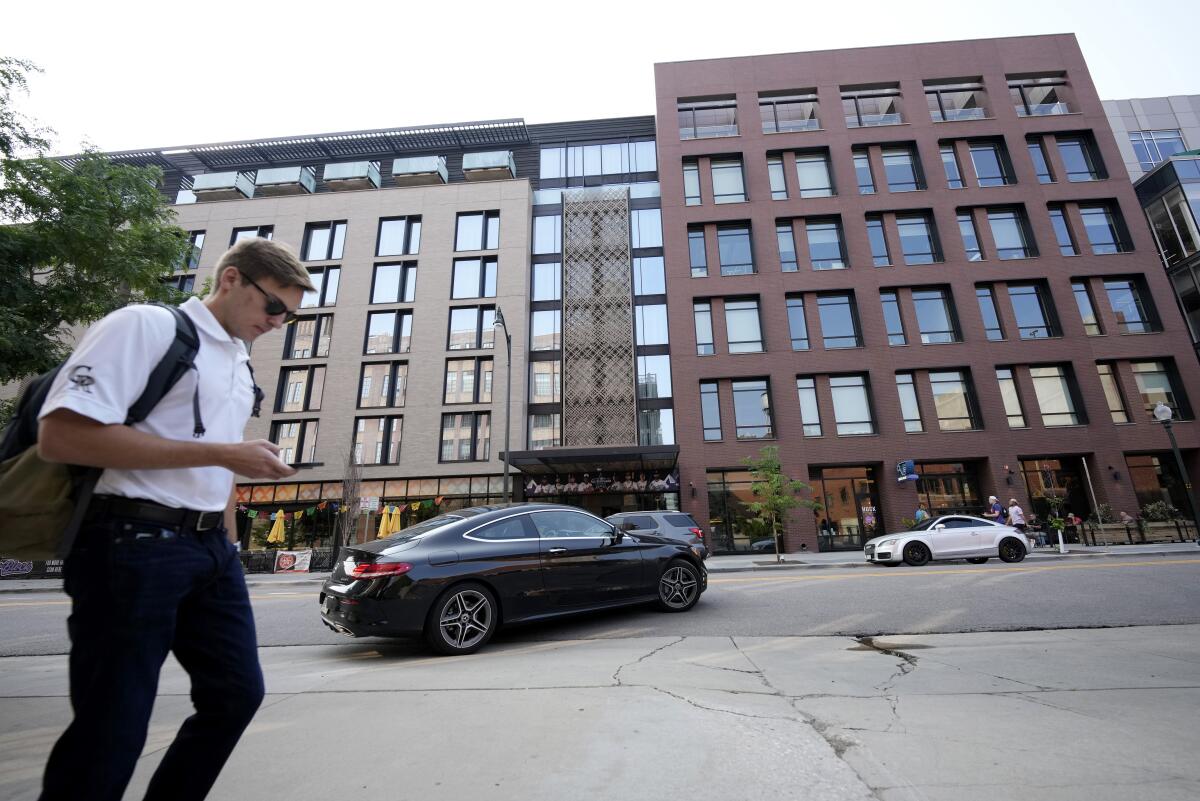 Una persona camina frente al Hotel Maven en el centro de Denver, el 11 de julio de 2021.