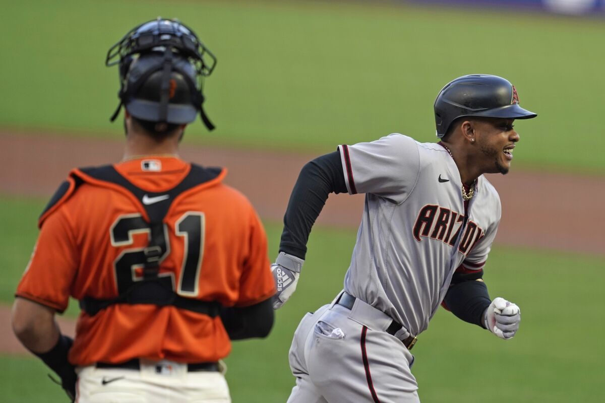 Arizona Diamondbacks' Ketel Marte heads for the dugout after hitting a home run off San Francisco Giants starting pitcher Tyler Anderson in the first inning of a baseball game Friday, Sept. 4, 2020, in San Francisco. Giants catcher Joey Bart, left, looks on. (AP Photo/Eric Risberg)