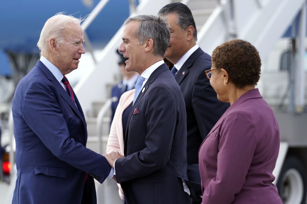 President Biden is greeted by then-L.A. Mayor Eric Garcetti and Karen Bass, who would succeed Garcetti, at LAX in  2022.