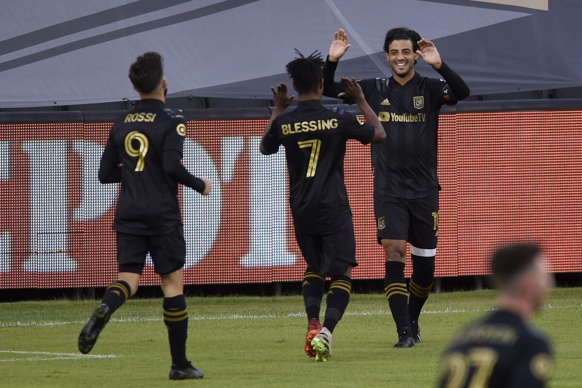 From right to left, Los Angeles FC's Carlos Vela celebrates his goal with Latif Blessing and Diego Rossi during the first half of an MLS soccer match against the Portland Timbers in Los Angeles, Sunday, Nov. 8, 2020. (AP Photo/Kelvin Kuo)