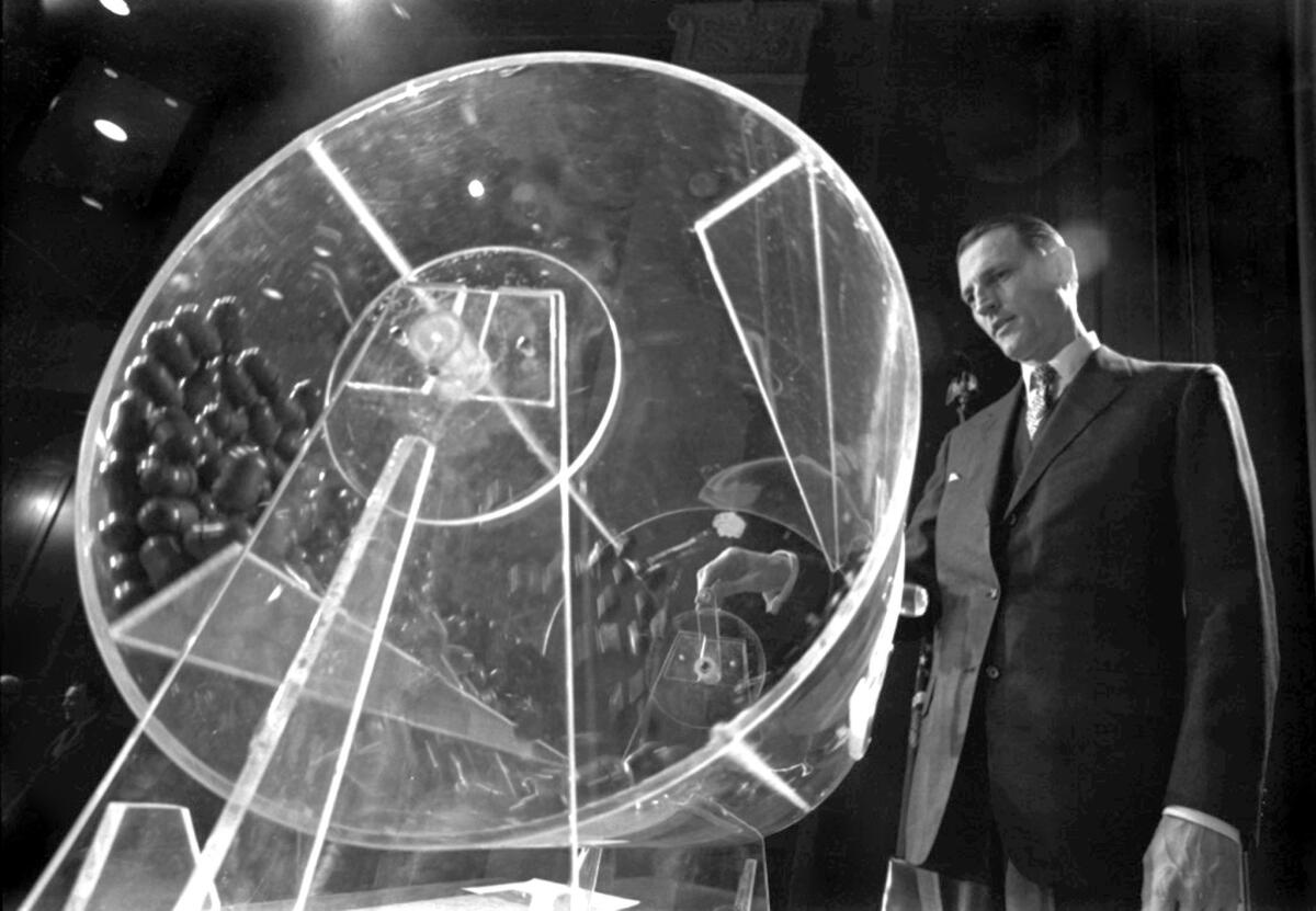 In 1972, Curtis Tarr spins a plexiglass drum holding capsules with the birth dates and orders for men born in 1953 at the beginning of the fourth annual Selective Service lottery in Washington. Tarr, who developed the lottery for the draft during the Vietnam War, has died at age 88.