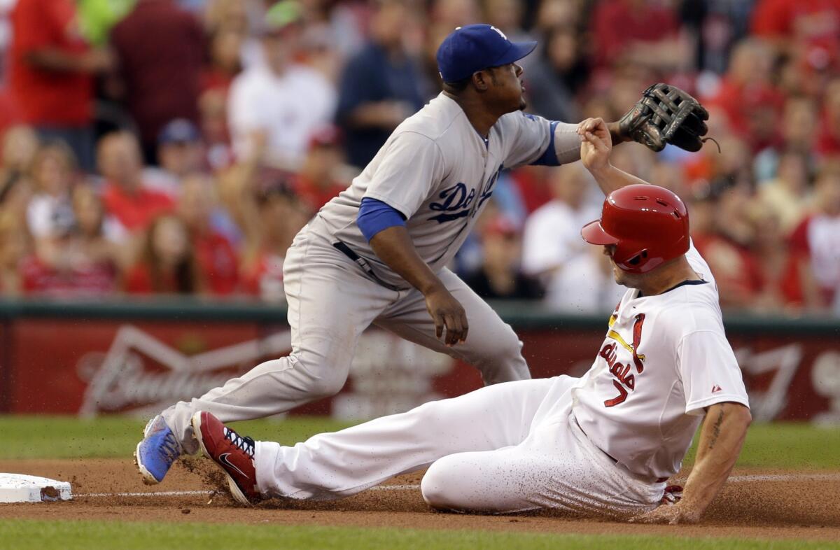St. Louis' Matt Holliday slides in safely to third base as the Dodgers' Juan Uribe waits for the throw in the first inning. The Dodgers lost to the Cardinals, 3-2.