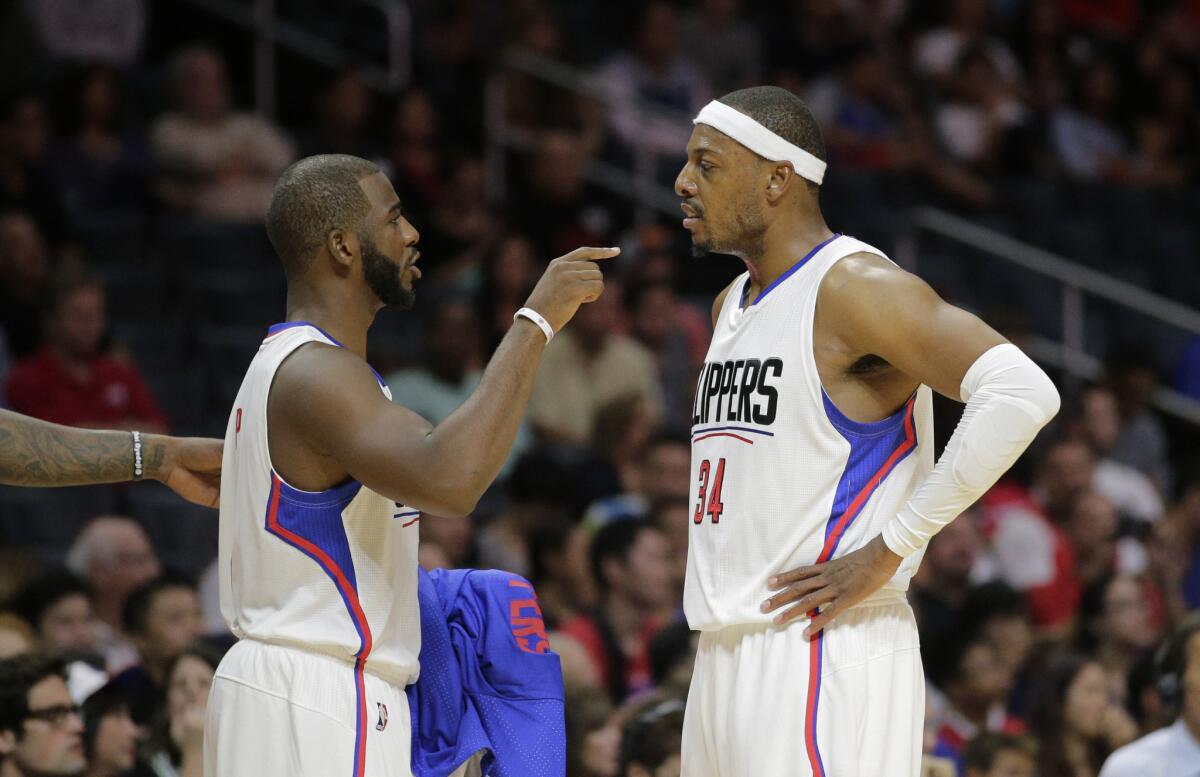 Clippers guard Chris Paul, left, talks to forward Paul Pierce during the first half of a preseason game against the Denver Nuggets on Oct. 2.