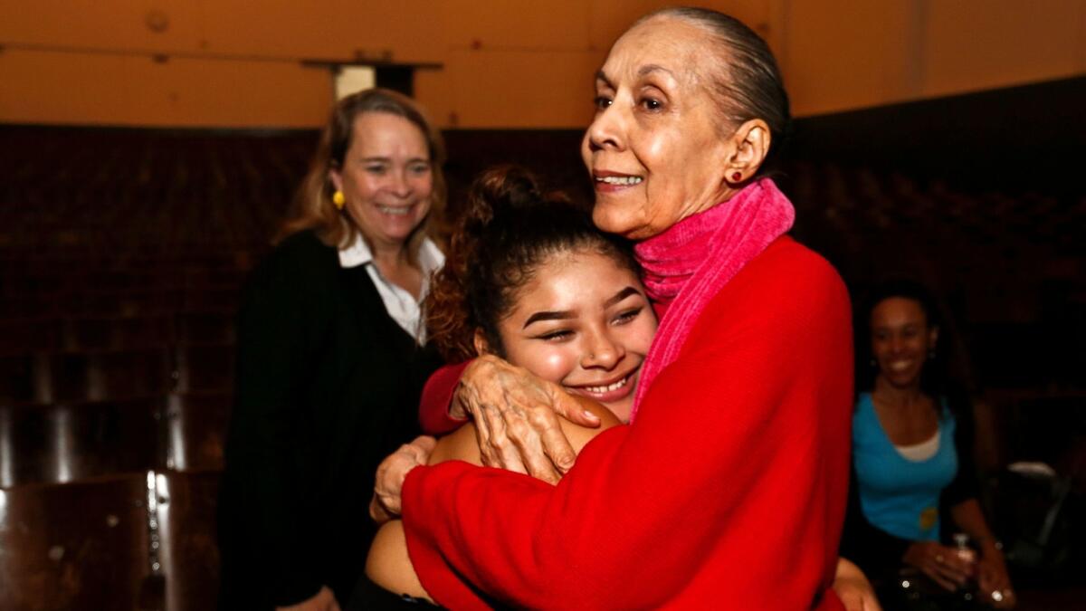 Carmen de Lavallade hugs 11th-grader Reyna Soriano, who performed a solo to welcome the dancer to Thomas Jefferson High.