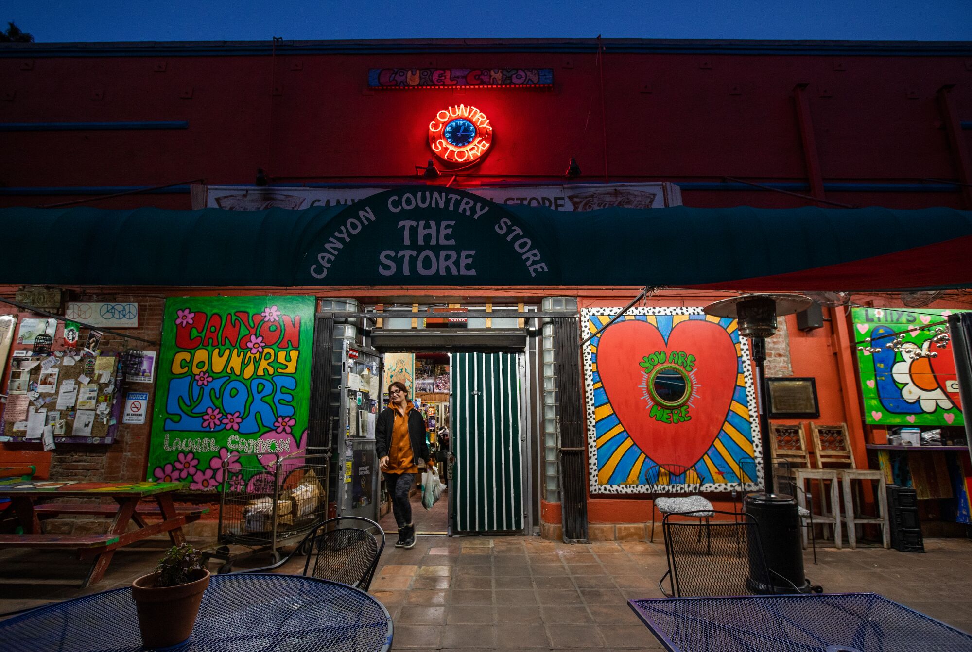 A customer makes her way out of the store, passing by the colorful murals that adorn the walls.