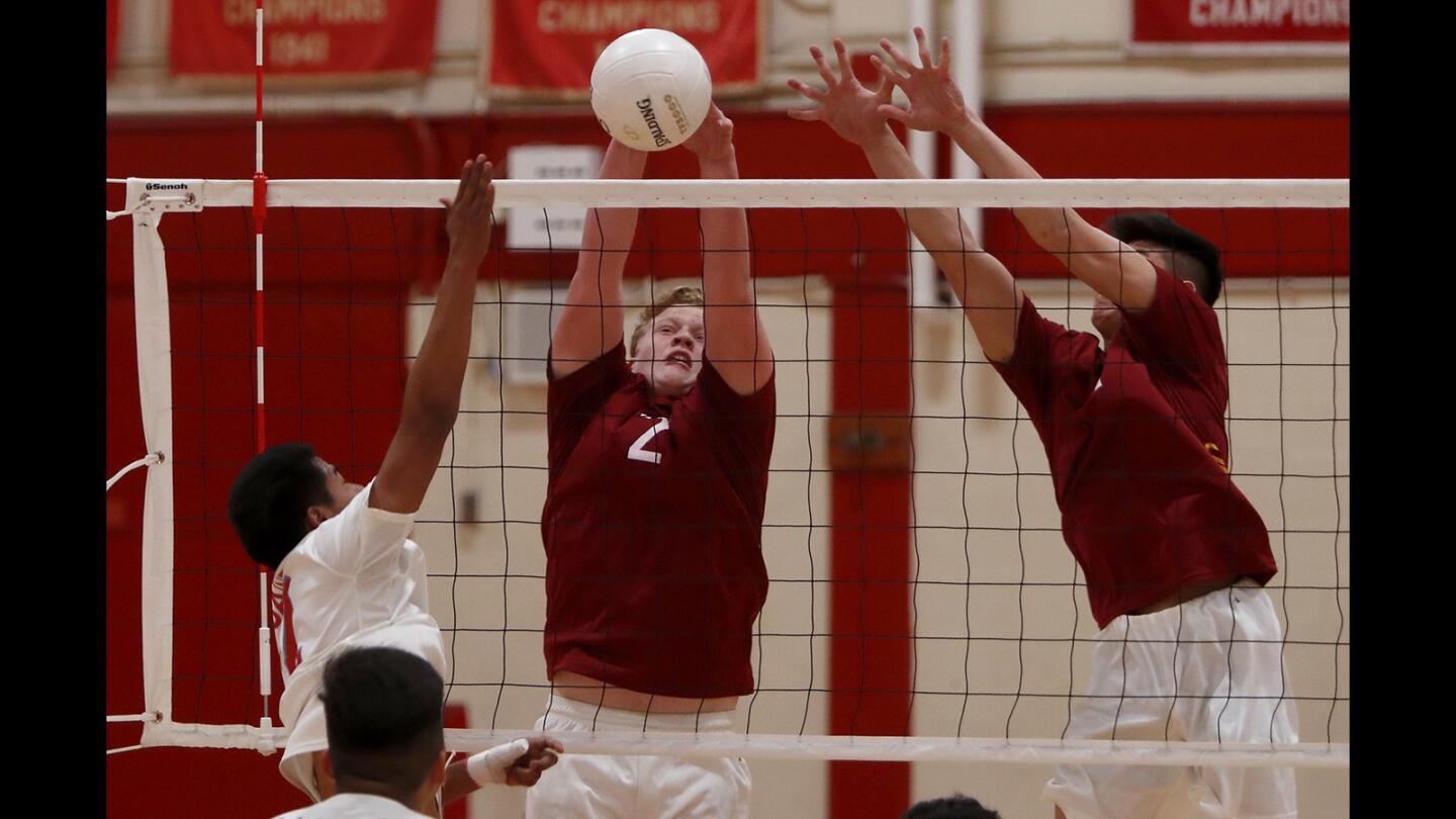Ocean View High's Hunter Miller, center, blocks a shot by Santa Ana during the first set in a Golden West League match on Friday, April 20.