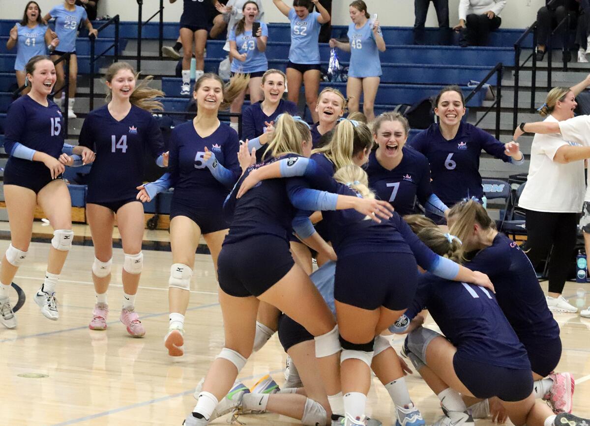 The Corona del Mar girls' volleyball team celebrates after beating Newport Harbor in the Battle of the Bay on Thursday.
