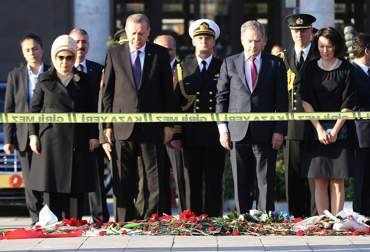 Turkish President Recep Tayyip Erdogan, second from left, and Finish President Sauli Niinisto attend a wreath-laying ceremony at the site of the twin bombings in Ankara.