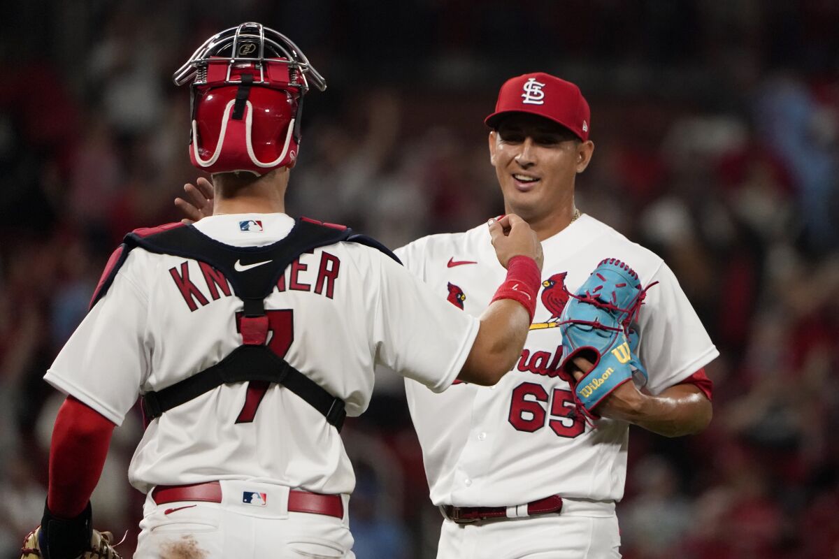 St. Louis Cardinals relief pitcher Giovanny Gallegos (65) and catcher Andrew Knizner celebrate a 6-5 victory over the Kansas City Royals in a baseball game Tuesday, April 12, 2022, in St. Louis. (AP Photo/Jeff Roberson)