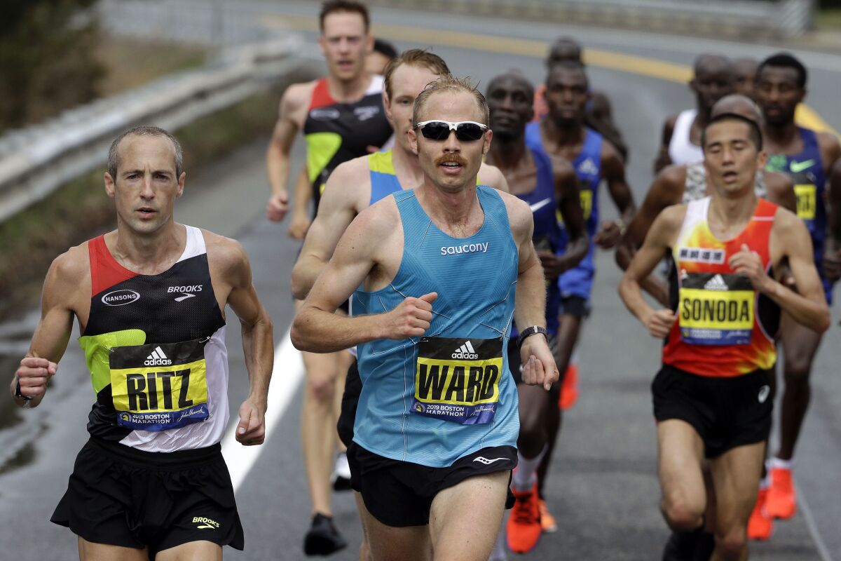 FILE - In this April 15, 2019, file photo, Jared Ward, center, of Mapleton, Utah, leads the pack during the 123rd running of the Boston Marathon in Natick, Mass. Elite runners competing in teams of three from places like Zimbabwe, Peru, Ecuador and across the U.S. will take the starting line Saturday, Sept. 12, 2020, for a unique sort of marathon relay race. Ward will be among the participants as he and his teammates race on their home course in Utah.(AP Photo/Steven Senne, File)