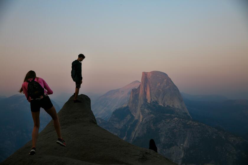 YOSEMITE NATIONAL PARK, CALIF. -- FRIDAY, JULY 21, 2017: Visitors catch a glimpse of Half-Dome at sunset, in the smoke-shrouded Yosemite National Park, Calif., on July 21, 2017. The smoke from the Detwiler fire burning near Mariposa is obscuring tourists views of some of Yosemite Valley's vistas. (Marcus Yam / Los Angeles Times)