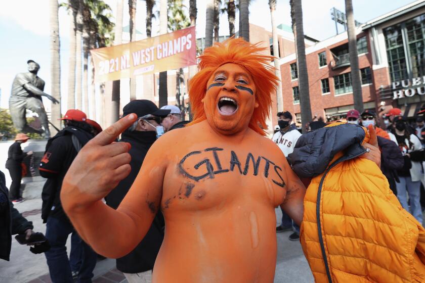 A San Francisco Giants fan waits outside of Oracle Park before Game 1 of a baseball National League Division Series between the Giants and the Los Angeles Dodgers Friday, Oct. 8, 2021, in San Francisco. (AP Photo/Jed Jacobsohn)