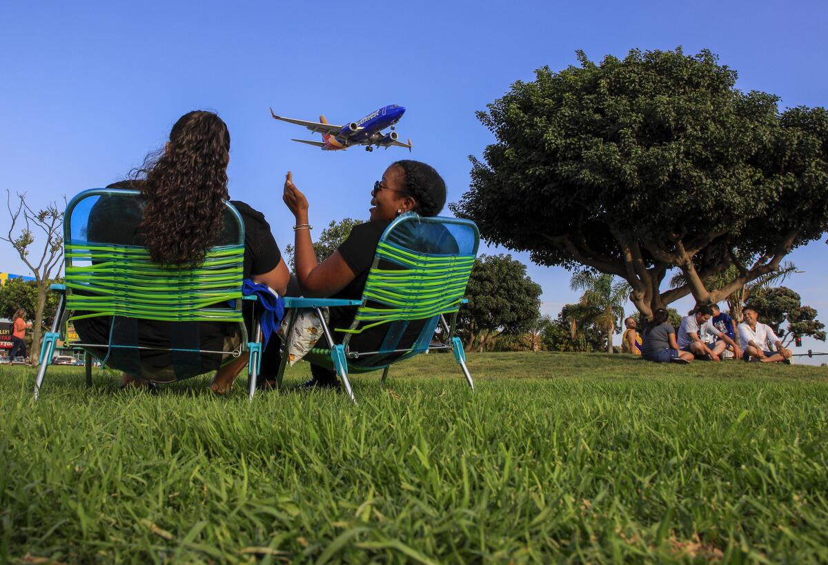 People watch planes land at LAX from a park in Westchester. 