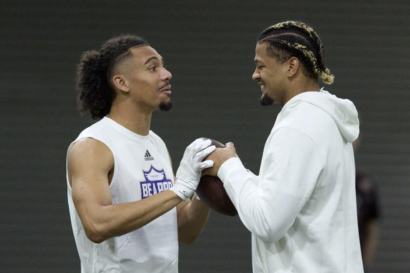 Washington wide receiver Jalen McMillan, left, greets fellow wide receiver Rome Odunze during Washington's NFL Pro Day, Thursday, March 28, 2024, in Seattle. Odunze did not participate in the day. (AP Photo/John Froschauer)