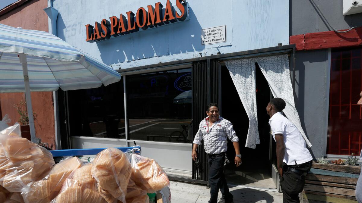 Wilson Lopez, center, exits the newly reopened Las Palomas bar in Boyle Heights.