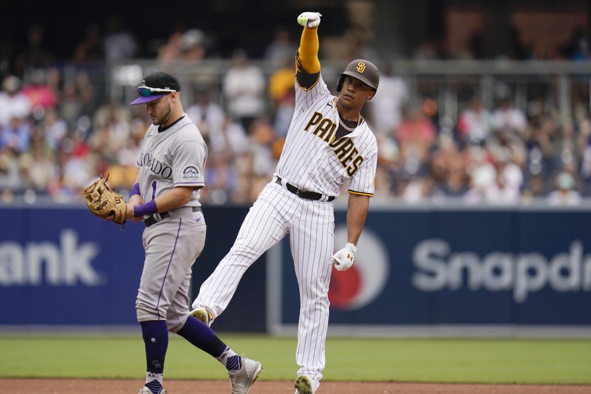 San Diego Padres' Juan Soto, right, reacts after hitting a double, next to Colorado Rockies shortstop Garrett Hampson during the seventh inning of a baseball game Thursday, Aug. 4, 2022, in San Diego. (AP Photo/Gregory Bull)