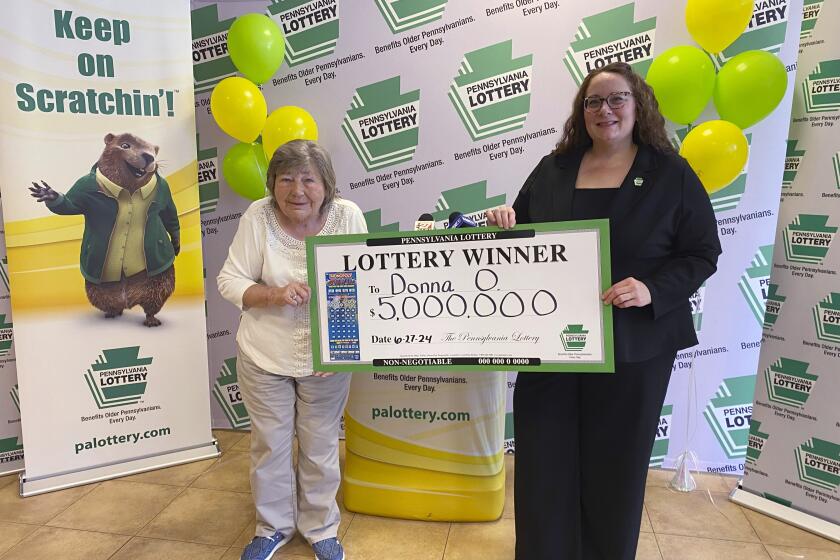 En la imagen, proporcionada por la lotería de Pensilvania, aparece Donna Osborne, de 75 años, izquierda, posando para una foto con la subdirectora de ventas corporativas de la lotería de Pensilvania, Staci Coombs, en las oficinas generales de la lotería en Middletown, Pennsylvania. (Lotería de Pensilvania vía AP)