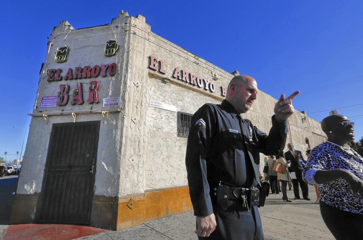 LAPD Officer Justin Fuller speaks with community members before the announcement of the city's closure of the El Arroyo Bar in South Los Angeles on Tuesday.